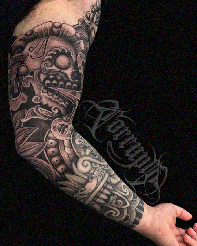 Inked Traditions: Monochrome Mask Arm Tattoo